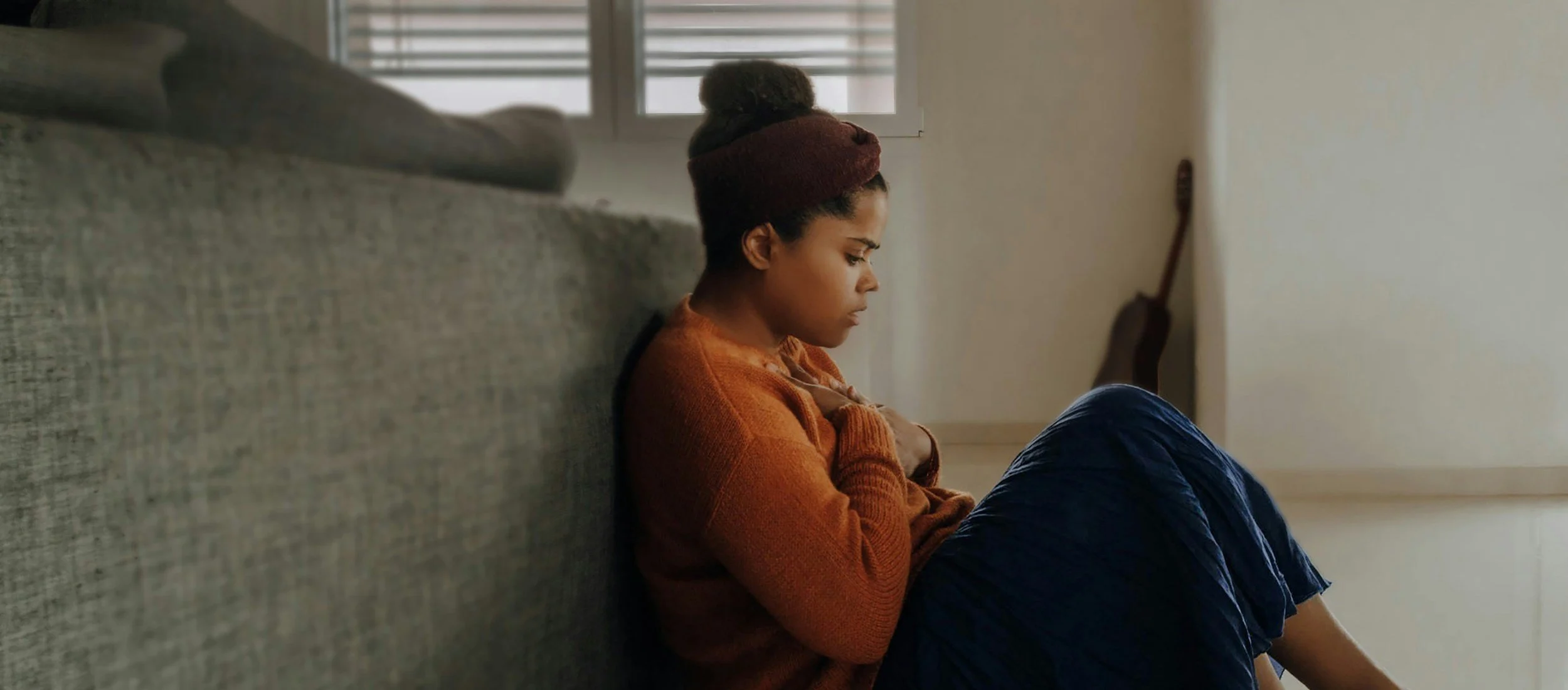 Woman-Anxiety-2500x1100-unsplashwebp Woman leaning against couch showing anxiety