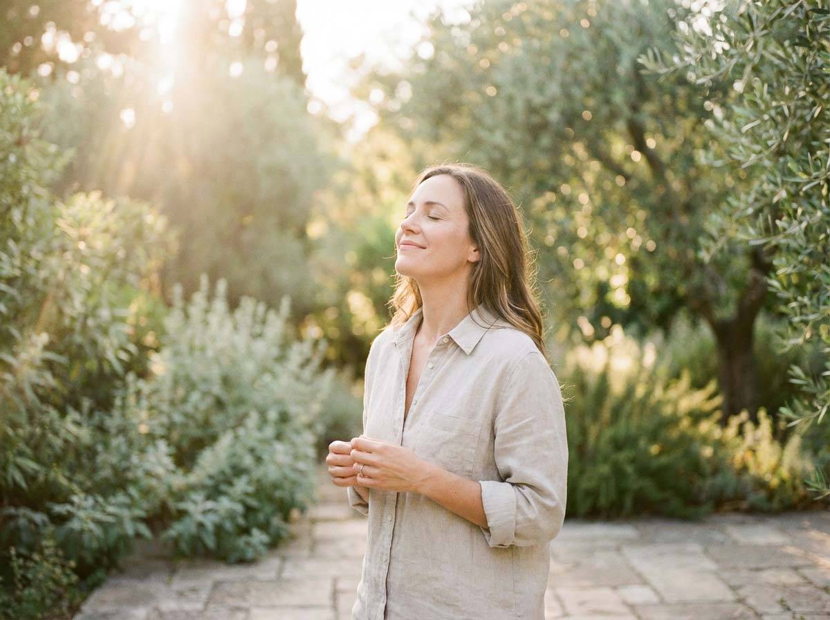 Woman standing peacefully in a garden