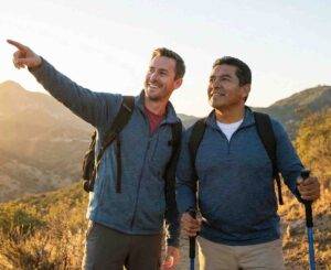 Two men hiking and pointing toward mountains for men's issues therapy